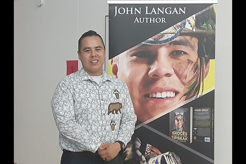 John Langan photographed in front of a banner of his book
