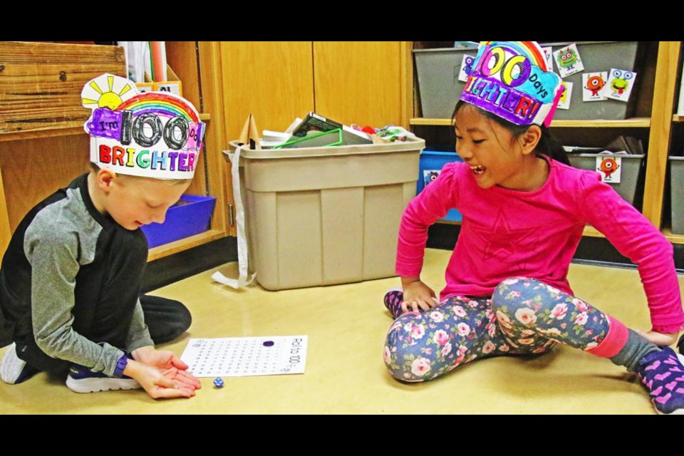 Grade 1 students Nash S. and Ameerah S. had fun with a game to mark the 100th day of school, while sporting custom-coloured hats that also marked the day at St. Michael School on Friday.
