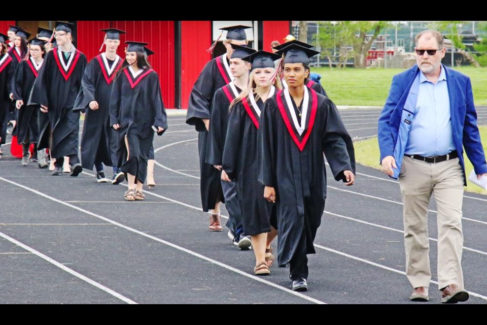 Teacher Darren Abel led the grads out onto the track, and then directed them onto the field to their seating as their families and friends watched and applauded