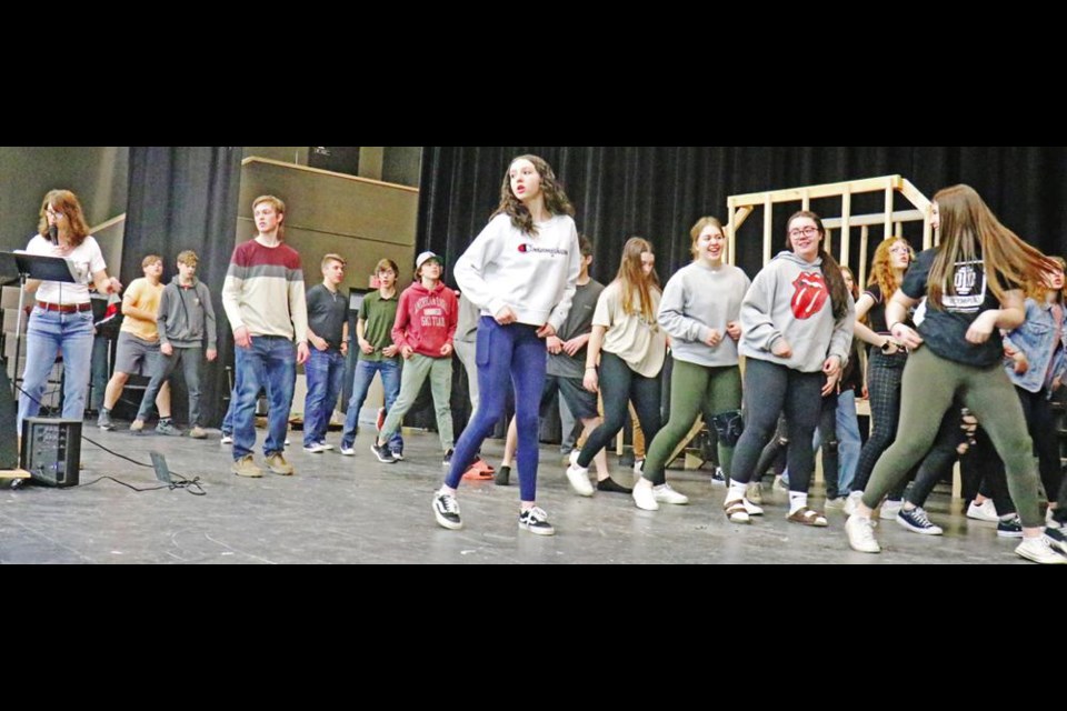 Some of the cast of 60 actors and actresses rehearse a song-and-dance number for the stage musical of “Grease” after school on Wednesday at the Cugnet Centre. In front are Liam Evans as Danny Zuko, and Brittany Barber, who is the understudy for the character of Sandy Dumbrowski, with director Tanya Cameron at left leading the group through the songs.