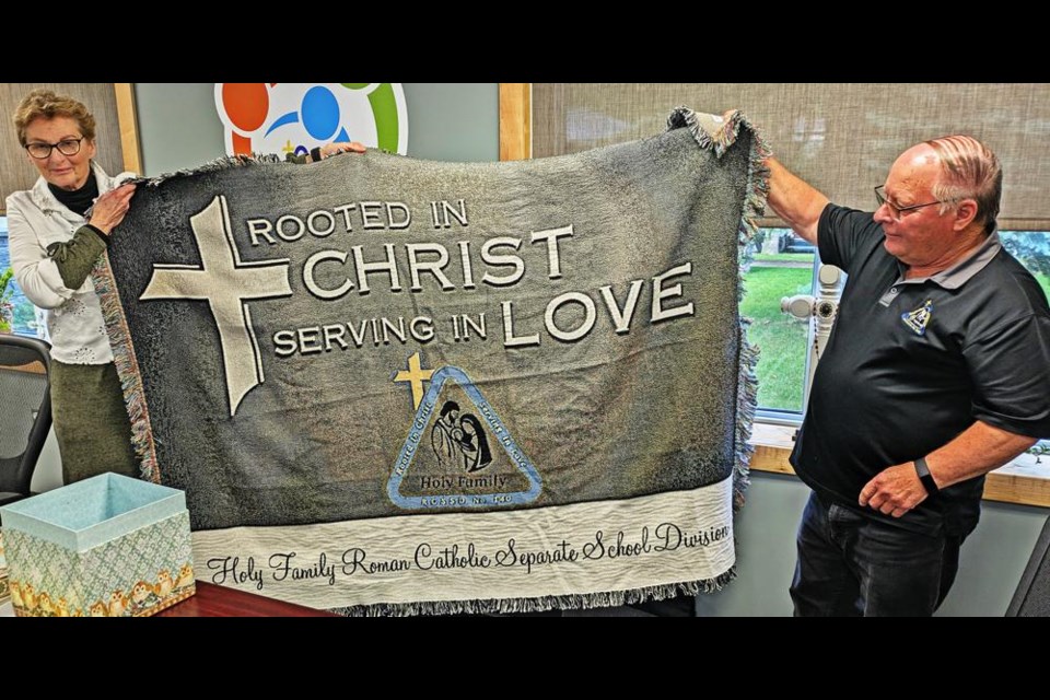 Out-going education director Gwen Keith accepted this gift from Holy Family board chair Bruno Tuchscherer at her last board meeting on Wednesday evening.