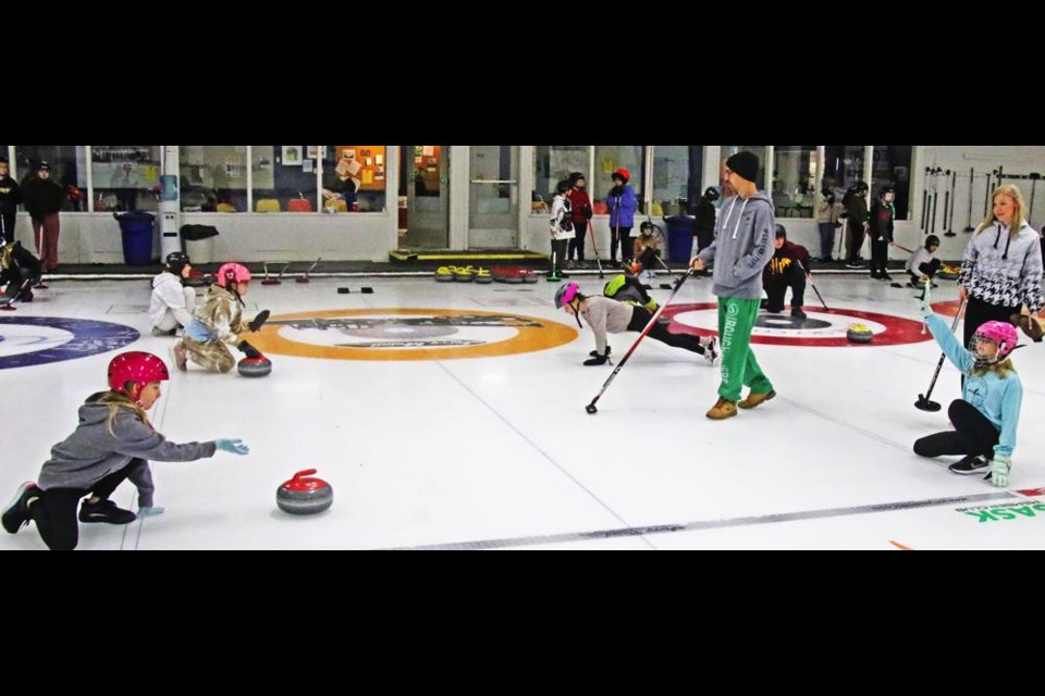 Grade 5 students practice throwing a rock to one another, at a learn-to-curl session for APES students on Friday morning.