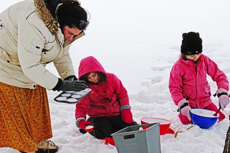 Leslie Richards joined her daughters Teresa and Cecilia in making snow muffins, as part of Family Literacy Day activities outside at the Weyburn Public Library on Thursday