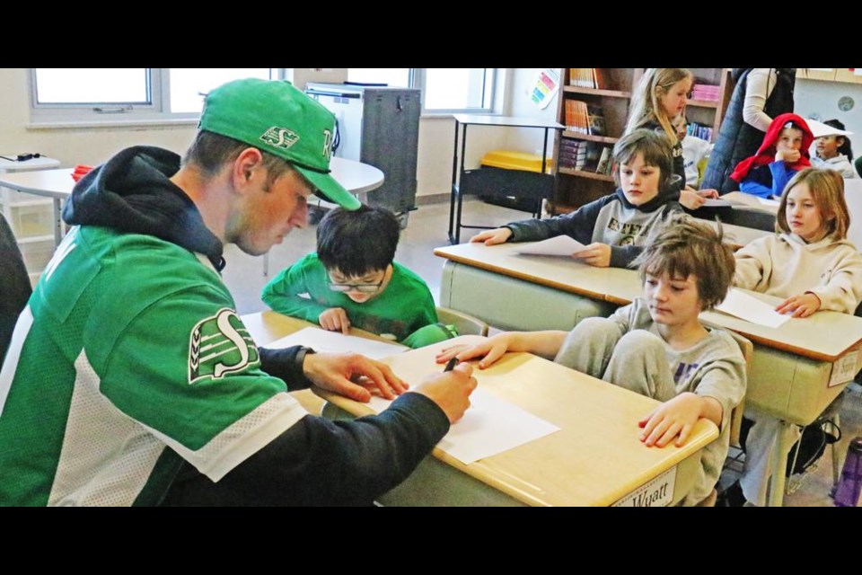 Mitch Picton, a wide receiver for the Roughriders, signed autographs for those students who wanted one, during a classroom visit on Friday at St. Michael School.
