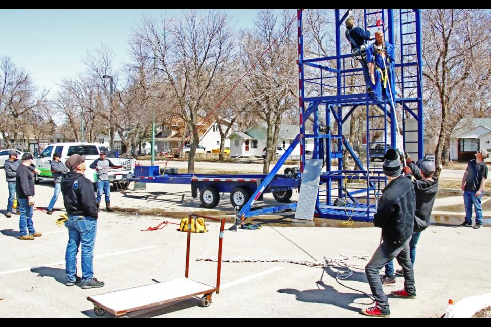 Workers on the ground had safety lines, at left, and the main rope and pulley at right for lowering the "injured" co-worker from the rig.
