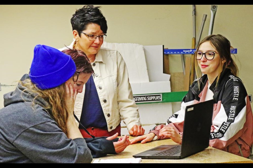 Teacher Joanne McLeod chatted with one of the families taking in the laser-etching activity at St. Michael School.