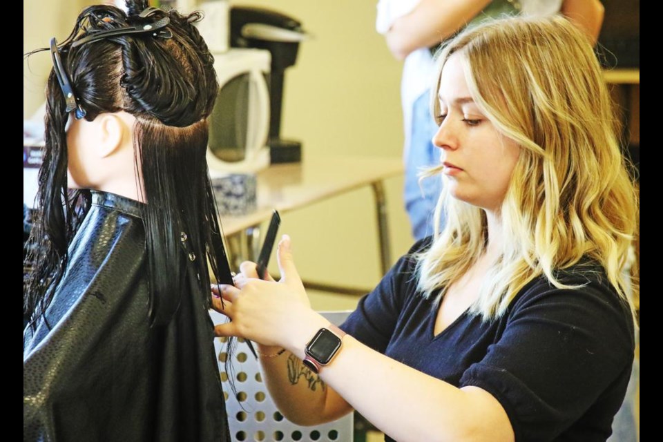 Ashley Hughes, from Elite Training Centre in Moose Jaw, worked on her hair design on Friday.