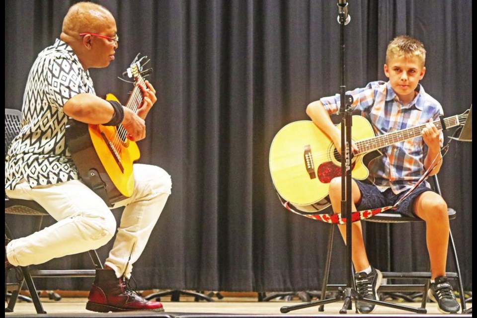 Nikolas Nikulin played guitar and sang, accompanied by his guitar teacher, Alfredo, at the Tiger Talent showcase on June 6.