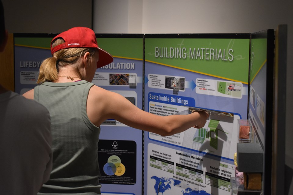 A student reaches for an interactive 'Smarter Science Better Buildings' (SSBB) display at the WDM. 