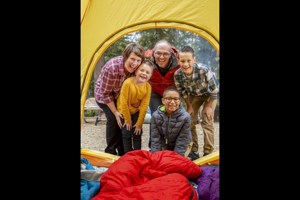 A family enjoys a camping adventure at Beaver Glen Campground in Prince Albert National Park.