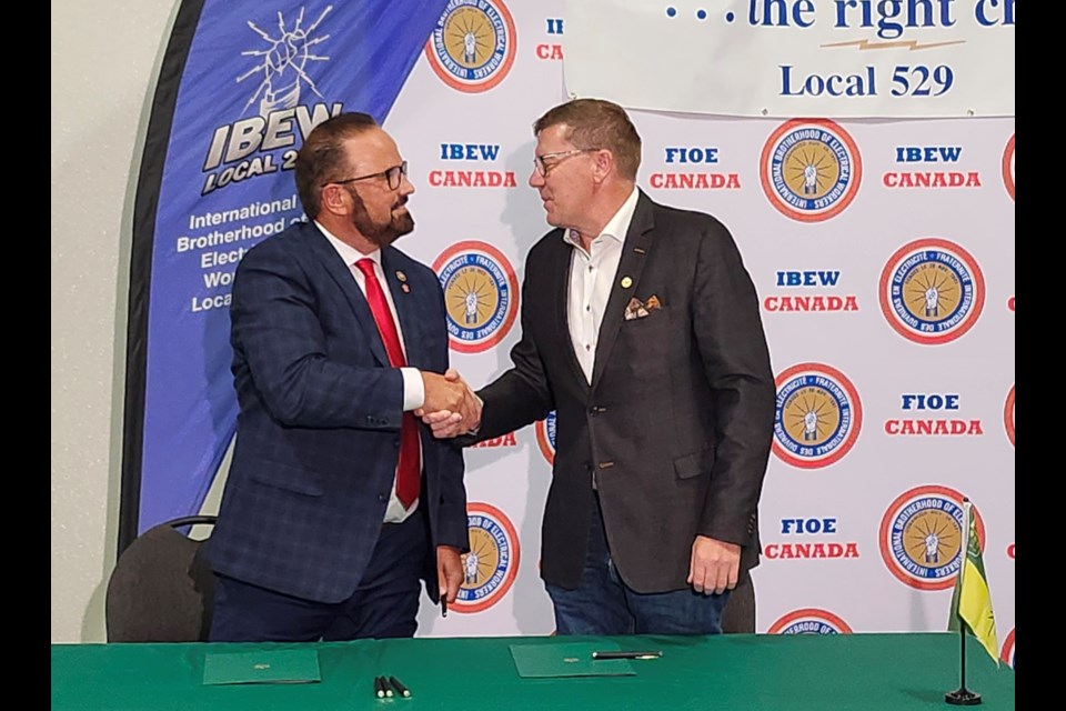 Premier Scott Moe, right, and International Brotherhood of Electrical Workers First District International Vice President Russ Shewchuck shake hands after sealing the apprentice and training partnership on Thursday, Sept. 19, at the IBEW office in the city.