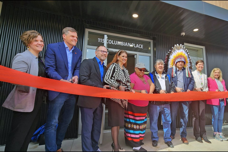 Elders Barb and Frank Badger, fifth and sixth left, join in the ribbon-cutting ceremony.