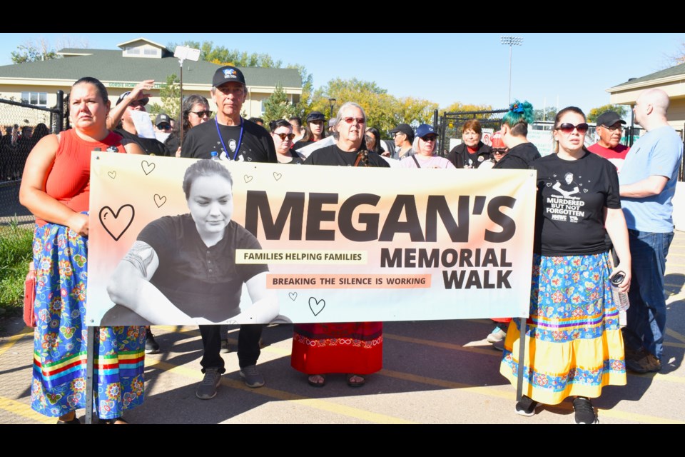 Brian and Debbie Gallagher, second and third left, walked behind a banner.