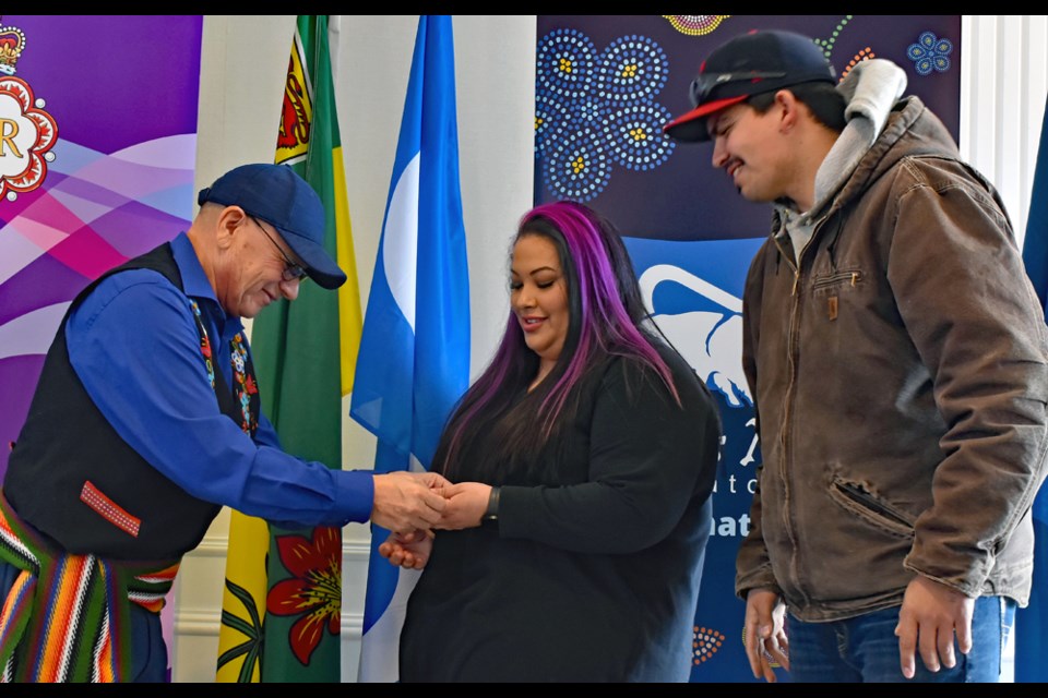 MN-S President Glen McCallum, left, presents one of the Jubilee Medals to the kids of Norman Fleury, Chantelle and Mark.