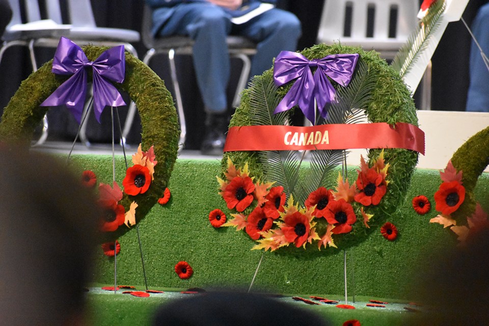 The Canadian wreath stands while people look on.