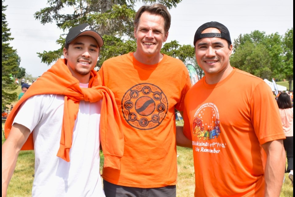 Michael and Amari Linklater with former Saskatoon Mayor Charlie Clark during the Rock Your Roots Reconciliation Walk last month.