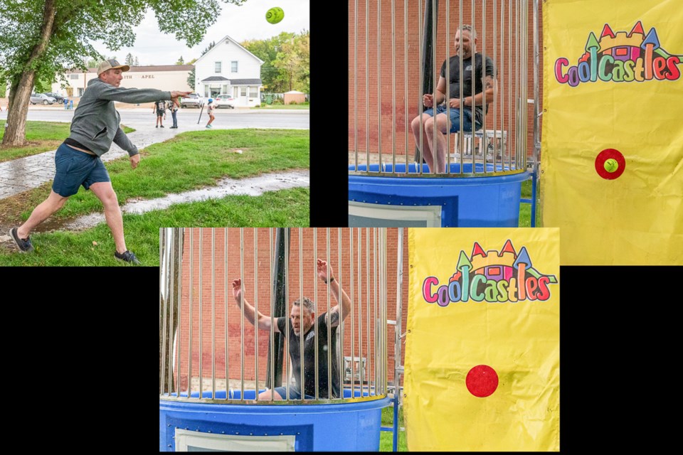 Sask MLA Jeremy Cockrill winds up and plants the ball on the bullseye to dunk Battleford's Mayor Ames Leslie.