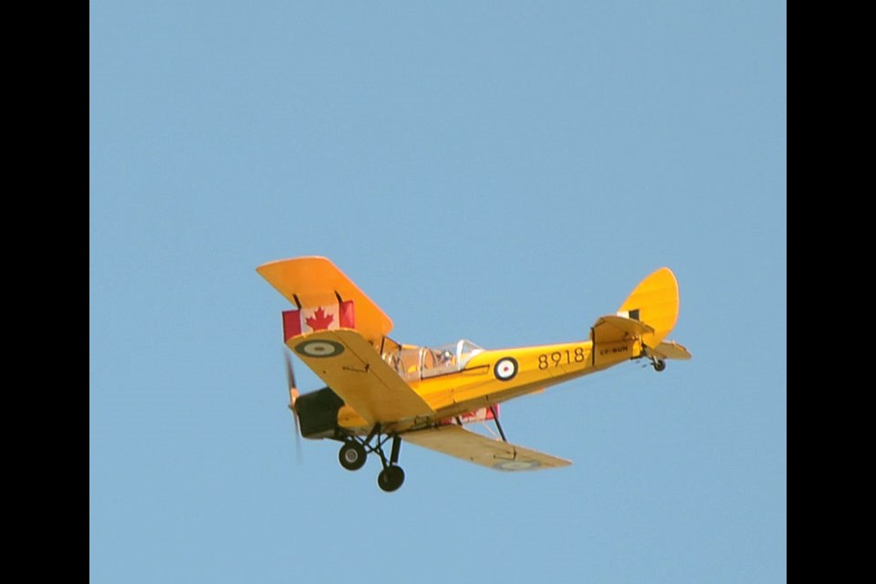 Norbert Glatt’s 1942 Tiger Moth flew overhead during a flag raising ceremony at Unity's Canada Day activities, with Canadian flags mounted on each side of the plane.