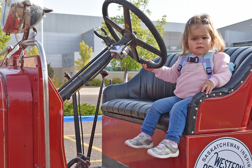 A young girl sits in the WDM's heritage vehicle