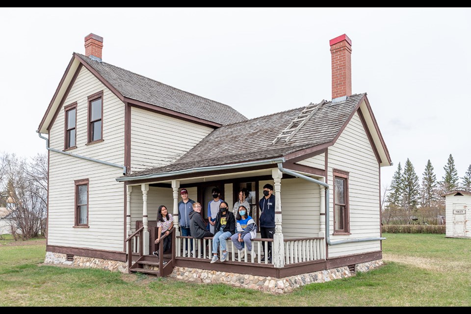 Notre Dame Elementary School students pose for a picture on the veranda of the Eatons House farmhouse of the North Battleford Western Development Museum after touring inside to see how the house was heated.