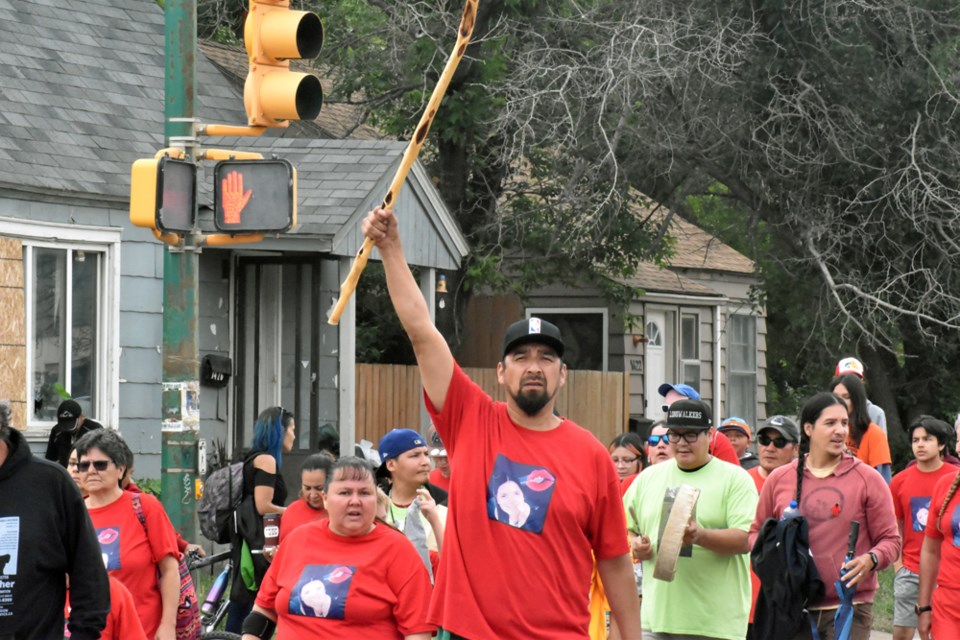 A member of the Morin family raises his walking stick to signify that their fight to bring Ashley home continues.