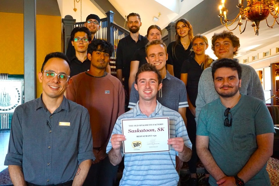 Andrew Mancini, centre, with restaurant general manager Esteban Martinez and some of his staff at The Old Spaghetti Factory.