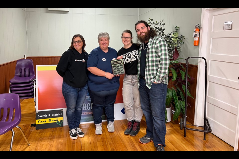 From left, Pennis Kimery and Mary McNair present winners Amanda and Keegan Smyth from Farmhand Tattoo their plaque for the Arcola Business Amazing Race. 