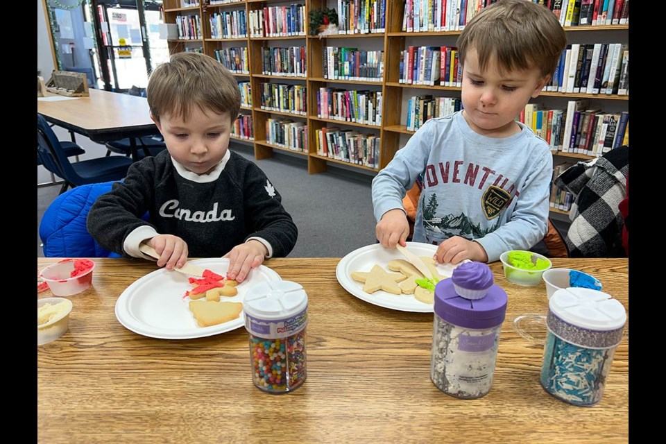 From left, Ryker and Milo Tessier enjoyed the cookie decorating at the Arcola Library during A Main Street Christmas. 
