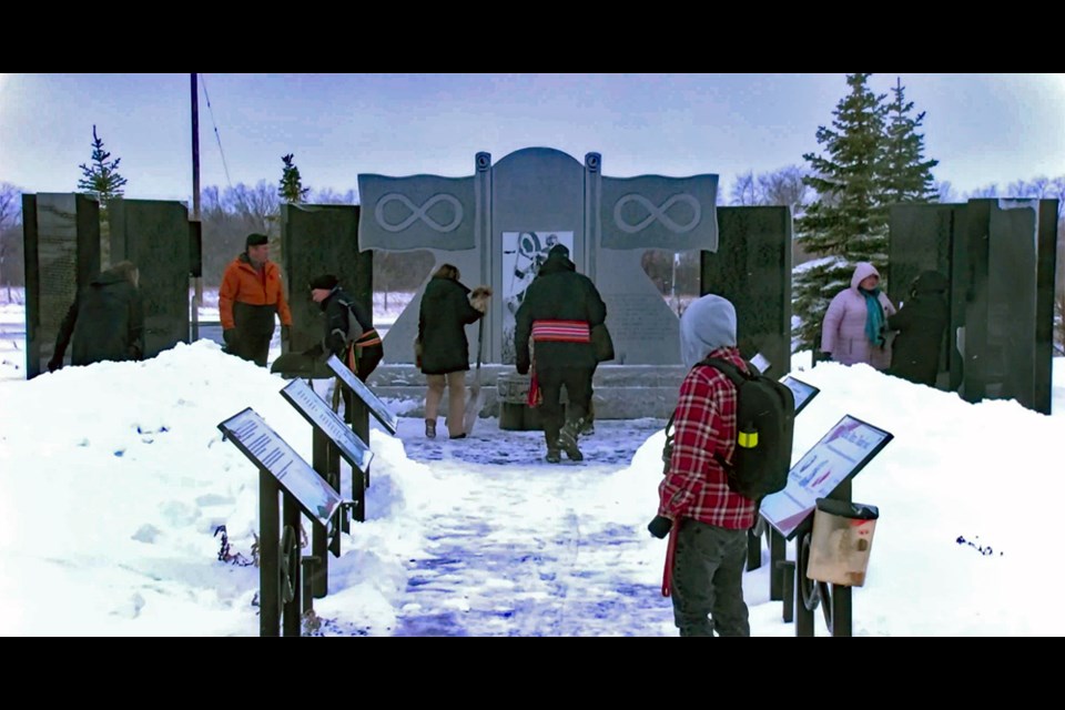 Organizers clear the snow at the monument before the start of the event on Tuesday, Nov. 8, at Batoche Festival Grounds. 