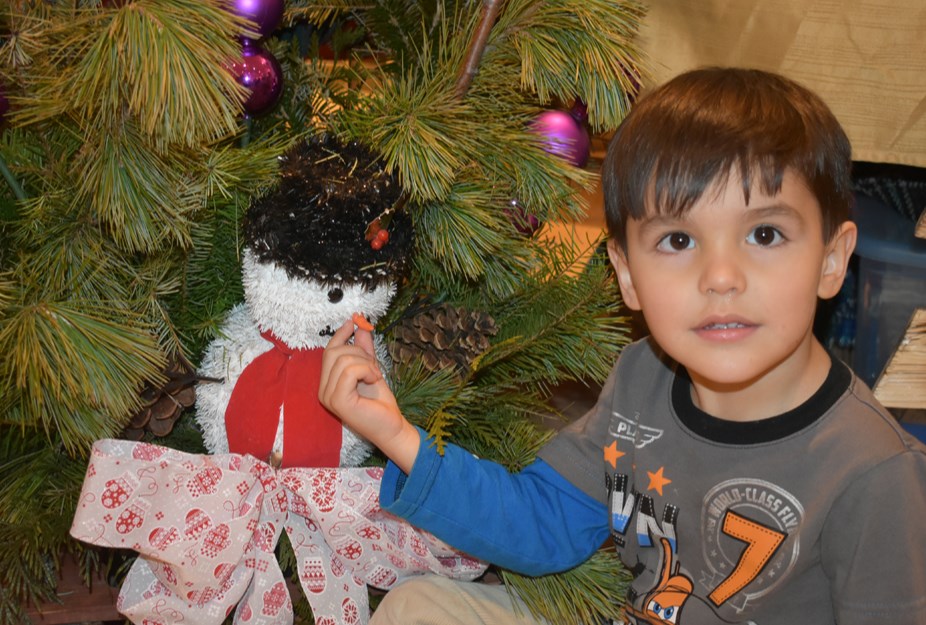 Rowan Babchishin of Canora found a cute character in a Christmas-decorated sleigh at the Kamsack Craft and Multicultural event Nov. 27, and had a hard time keeping his hands off the toy’s carrot-like nose.