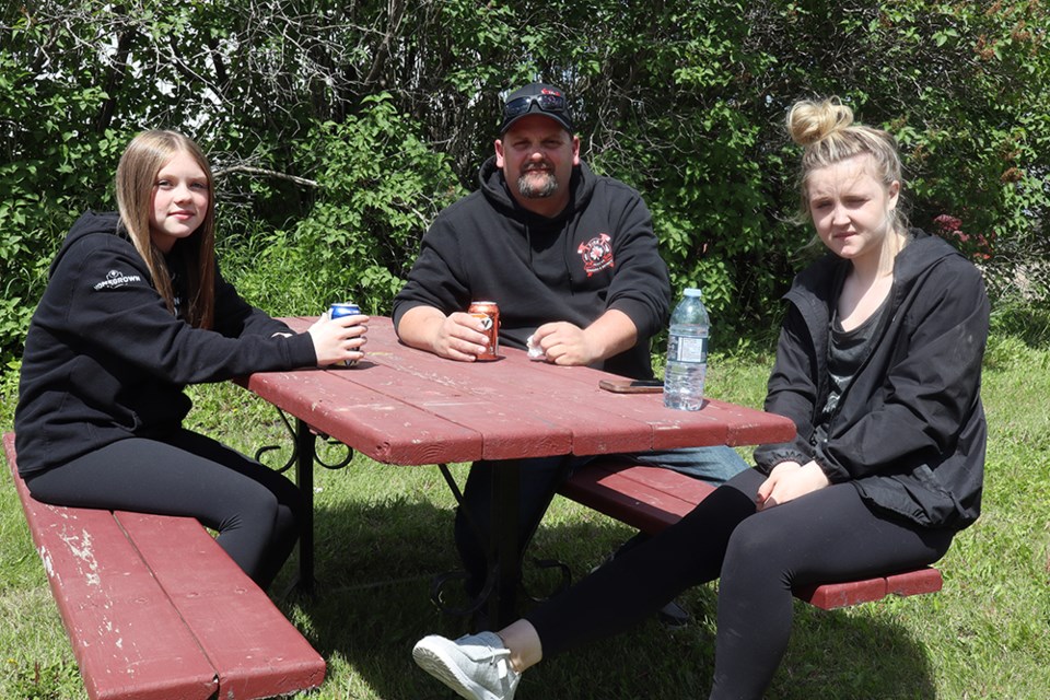 Ryea Harper (left) and her sister Jordan brought their dad Jess Harper to enjoy a burger and a beverage for only $5 at the Crossroads Credit Union member appreciation barbecue on June 19. All proceeds went to the Canora Filling the Gap Food Bank. 