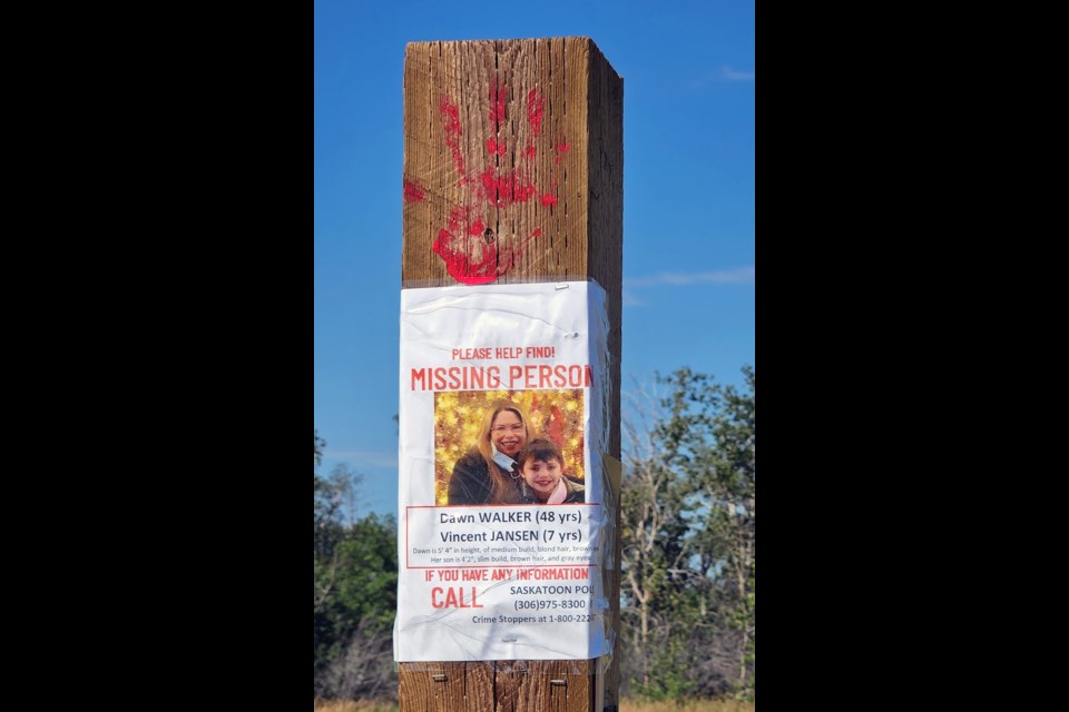 A red hand print is placed on top of the poster of Dawn Walker and her son  at Chief Whitecap Park.