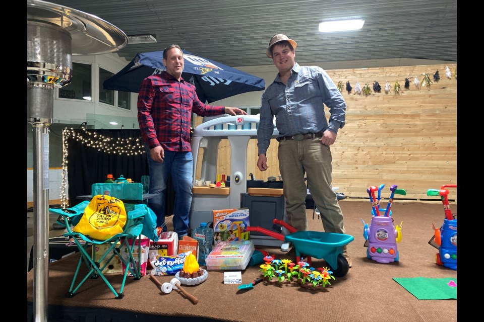 Kyle Walkeden and Brandon Lohse helping to display auction items. 