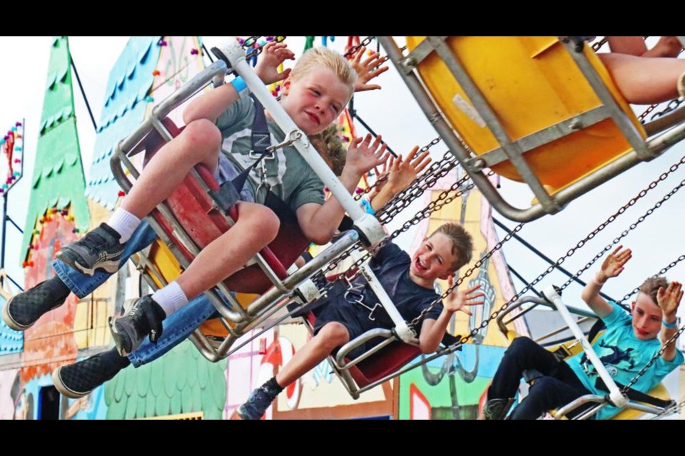 Riders on the swing chair held their arms up as the ride whipped them around at high speed, at the Weyburn Fair on Thursday.