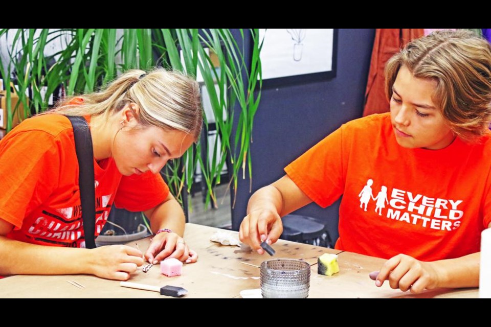 Addison Klapak and Kyro Klapak worked on some feather art at the Collabartive Studio on Friday, a fundraising event held for National Truth and Reconciliation Day.