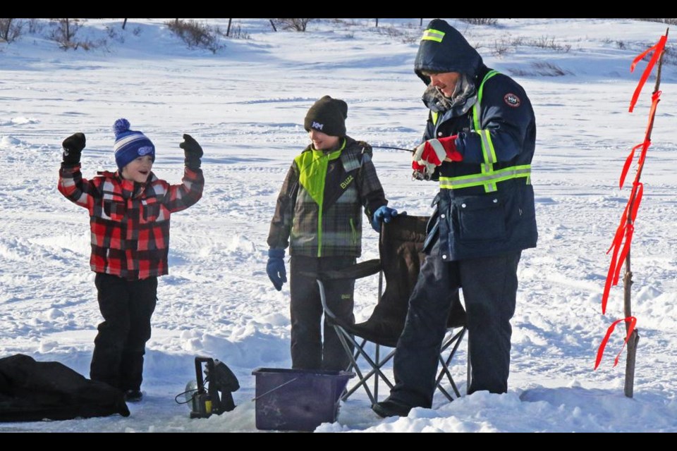A boy cheered as his dad reeled in a fish, during the Weyburn Wildlife Federation's fish derby, held on New Year's Day at Nickle Lake.