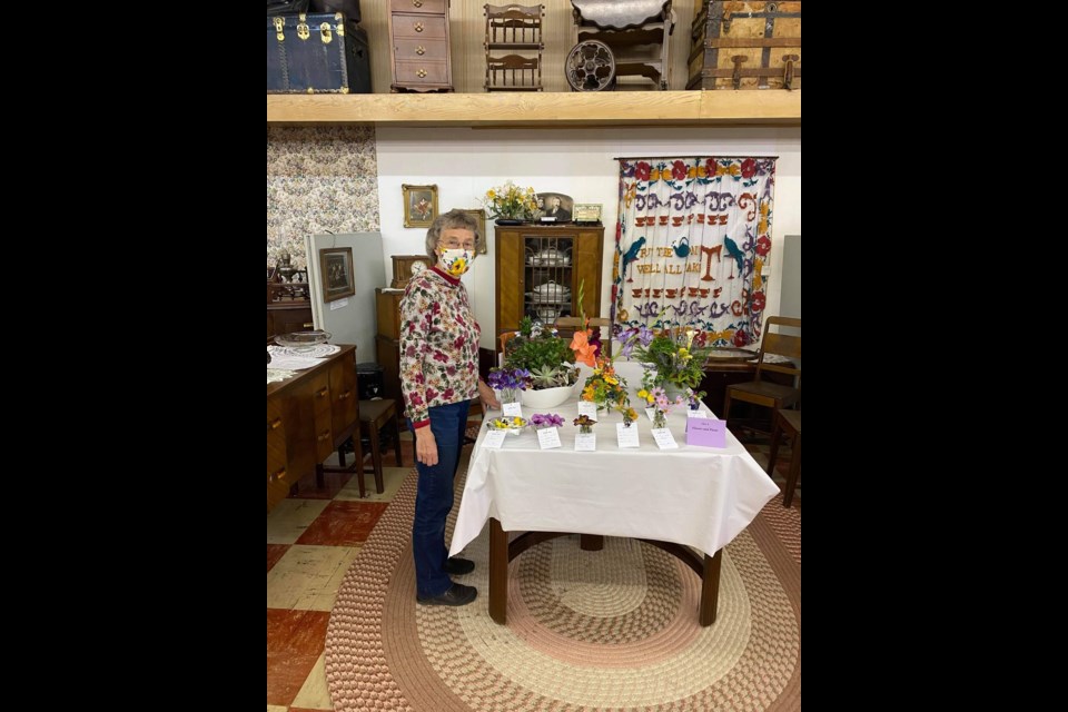 Dedicated community volunteer, Jean Halliday, clearly shows her winning smile beneath her mask at the museum's fall fair entries as part of the Sept. 11 Luseland Harvest Festival.