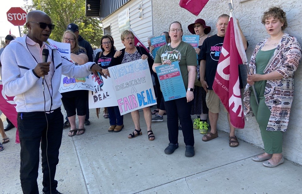 CUPE 5430 president Bashir Jalloh, left, and health-care workers gather outside Saskatchewan Health Minister Jeremy Cockrill's office in North Battleford on Aug. 20.