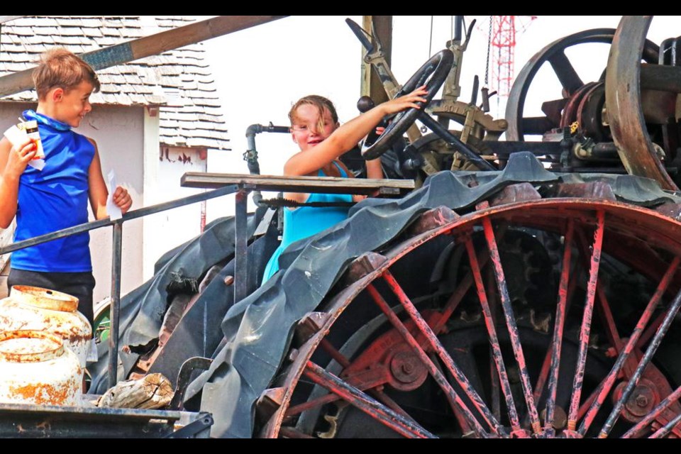 Blake Haider and Jayden Stewart explored the large antique steam tractor at Weyburn's Heritage Village on Friday.