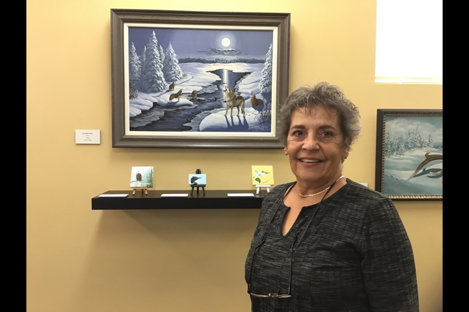 Jean M. Dunn in front of her work Moonlight Melody shown at the Allen Sapp Gallery.