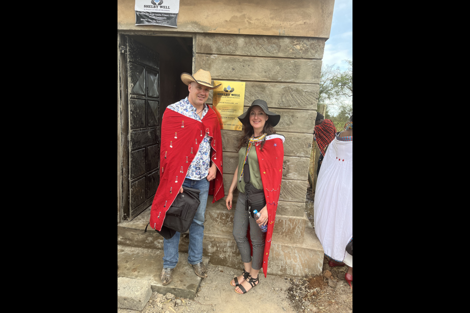 Wearing their red ceremonial capes, Troy and Crystal McNaughton visited the well installed in Kenya in memory of their daughter, Shelby Brandon.