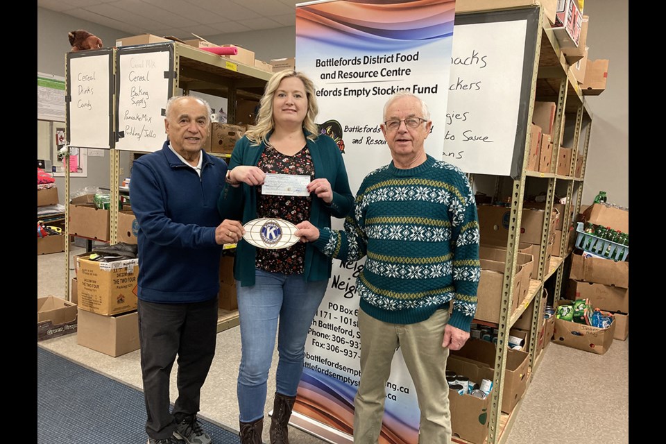 Don Backus and John Hunchak, on behalf of Kiwanis, present Erin Katerynych of Battleford District Food and Resource Centre with a $3,000 donation that will be added to their 2022 Empty Stocking Fund.