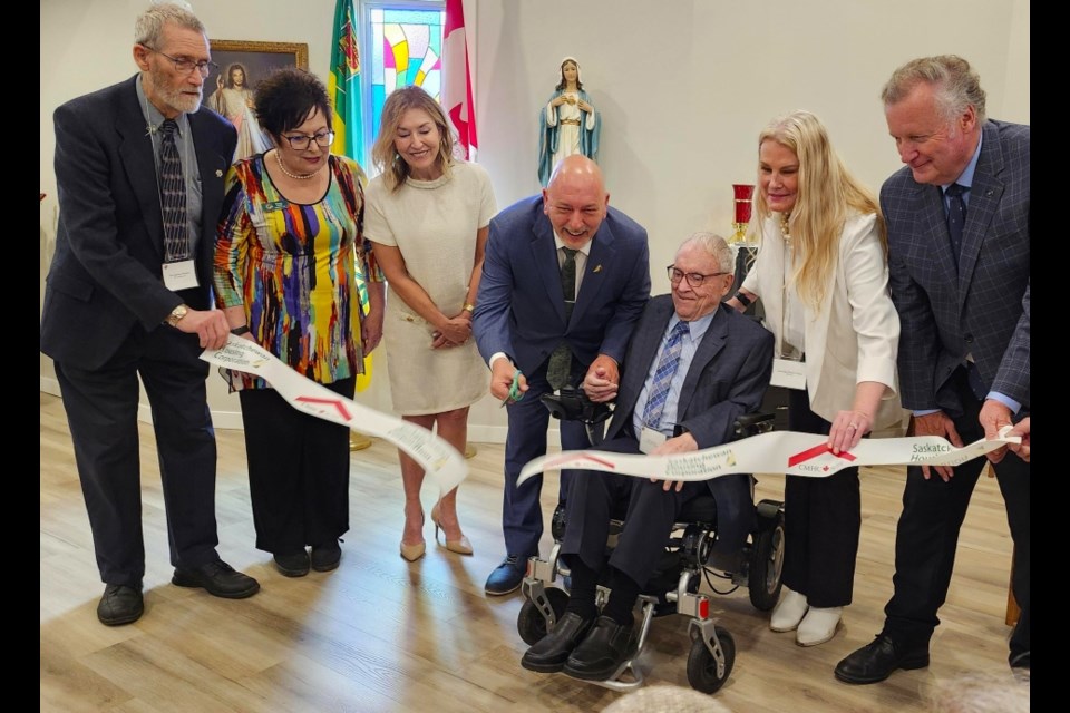 Martensville MLA Terry Jensen assists Knights of Columbus Charities Inc. co-founder Bob Jeanneau in cutting the ribbon.