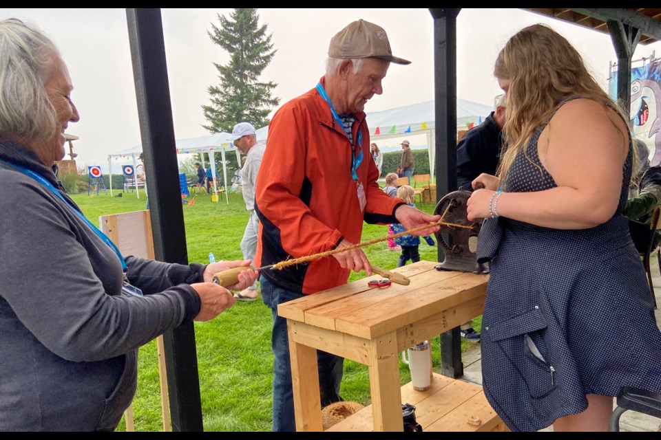 Volunteer Lorne Cooper, centre, gives a rope-making demonstration at the Family Fun Day.