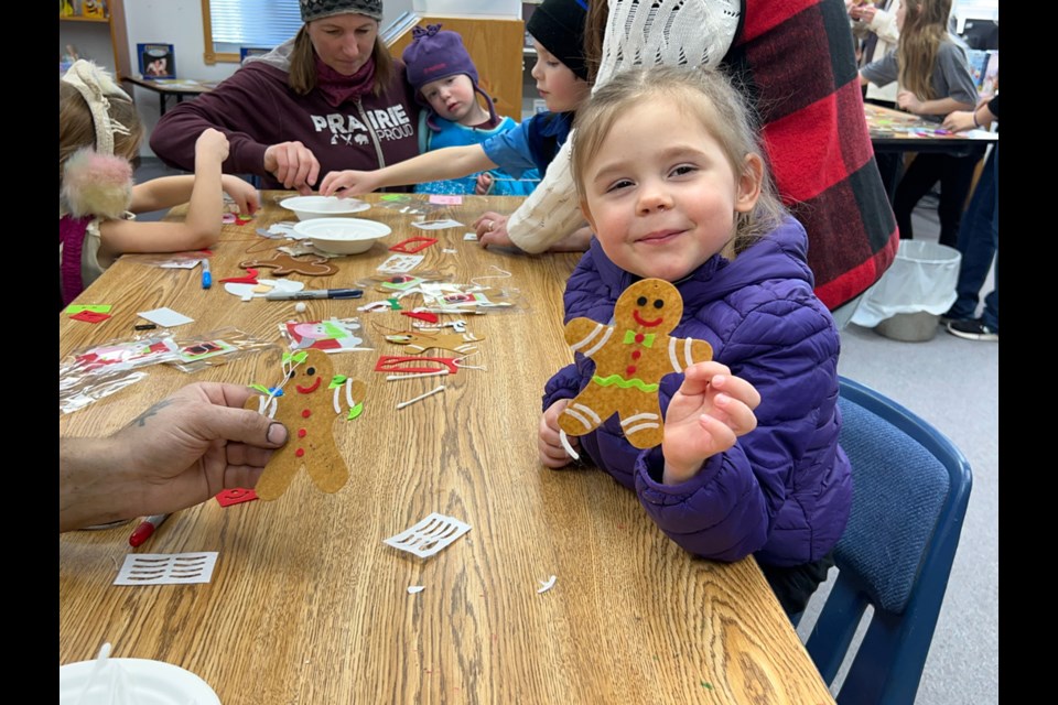 Three-year-old Ivy Mutz loved making her gingerbread man at the Arcola Library during the Main Street Christmas. 