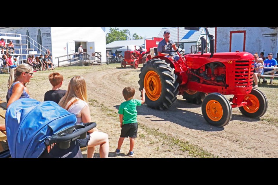 The parade of tractors from the Souris Valley Antique Association through the Heritage Village, shown here from a year ago, will be held at 2 p.m. on both Saturday and Sunday.