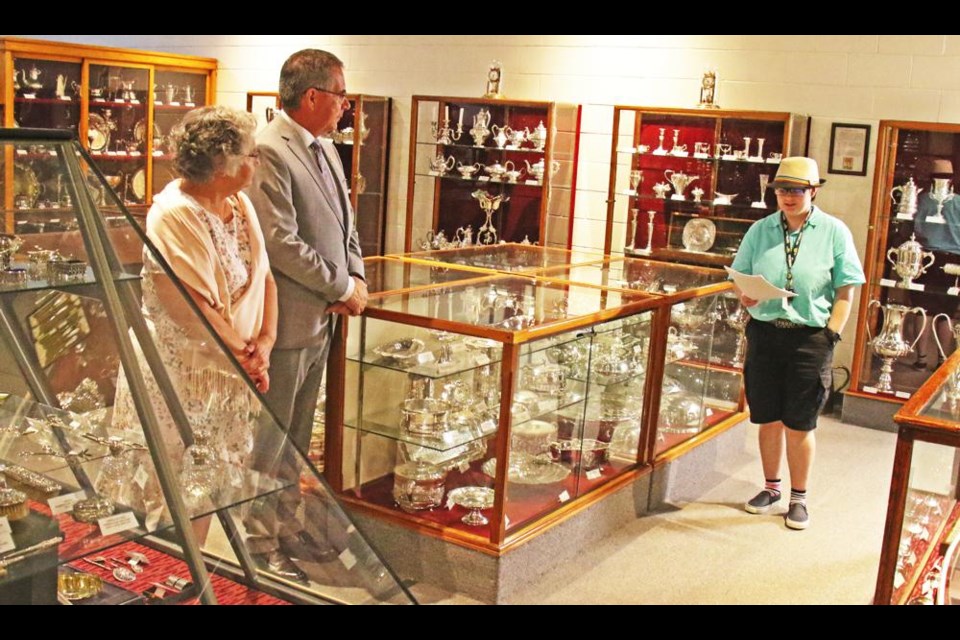 Soo Line Museum staff member Lauren McKinney, at right, gave a historical overview of the Charlie Wilson Silver Collection to Lieutenant Governor Russ Mirasty and his wife Donna, during a tour of the museum.
