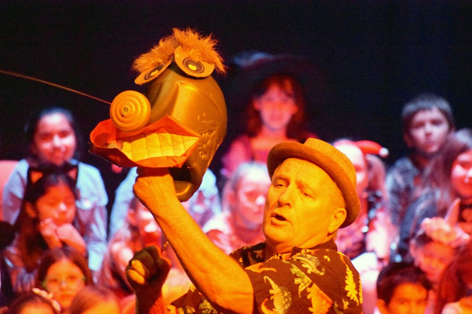 An animated watering can sprays the audience while the howlers look on.