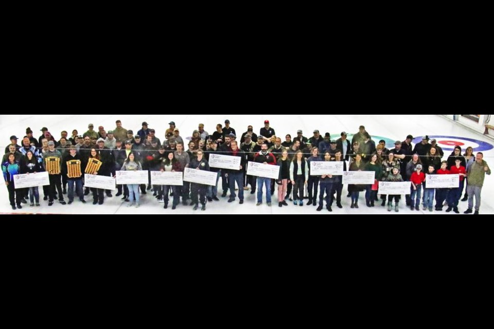 All of the curling teams, organizers and youth organizations who received a donation gathered for a group photo on the ice, at the opening ceremonies for the 65th annual Weyburn Oilmen's Bonspiel on Friday night. A total of $8,322 was donated to 10 community organizations that work with youth.