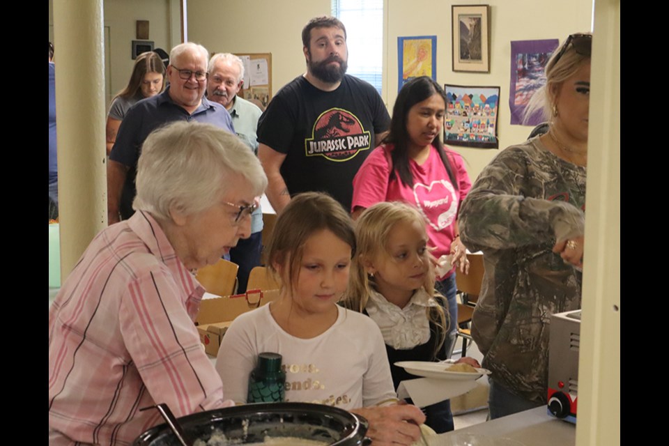 Volunteer Joy Stusek (left) helped make sure everyone in the lengthy lineup received their plate of perogies.